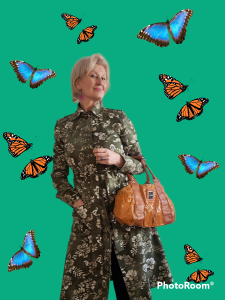 Nainen perhosten ympäröimänä takkimekossa jumissa
